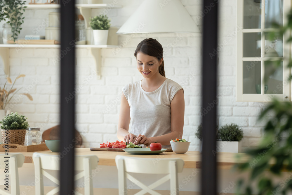 Φωτογραφία Happy smiling young woman mother or wife cooking healthy food for family at home
