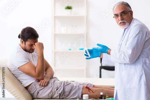 Leg injured man visiting old doctor in first aid concept