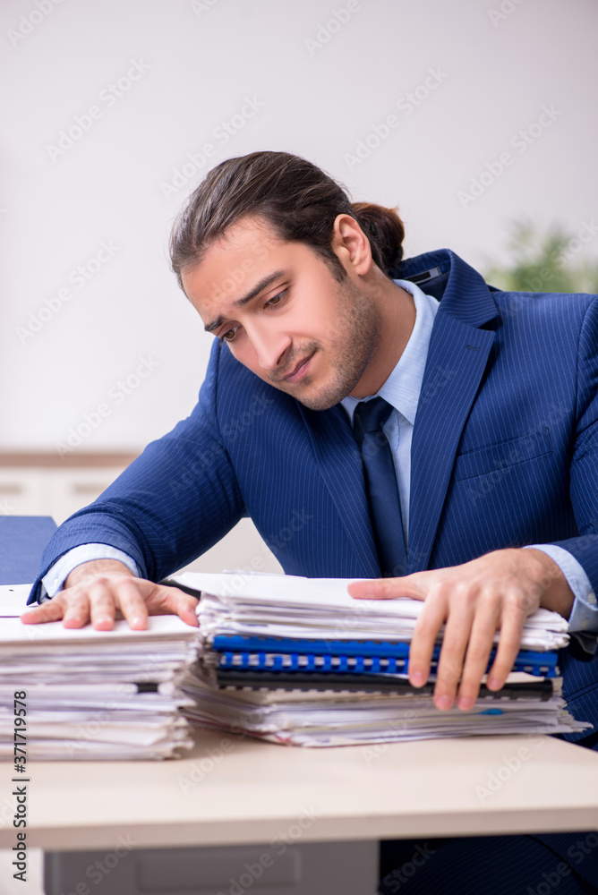 Young male employee unhappy with excessive work Young male employee unhappy with excessive work