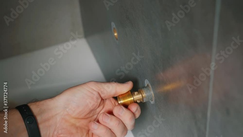 The plumber twists the exentric to install the mixer.