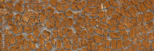 Texture of old cracked artificial leather. The surface of the dried leatherette with lots of cracks and pieces of brown material. Faux leather texture. Wide panoramic background for design.