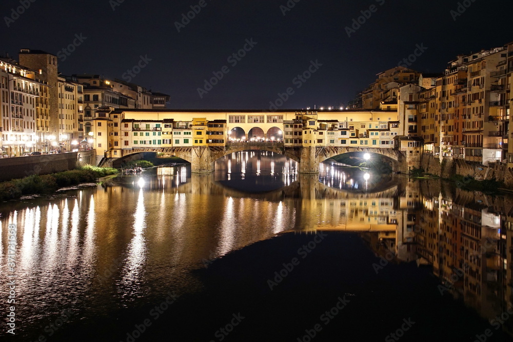Ponte Vecchio over Arno River panorama in Florence Italy at night.