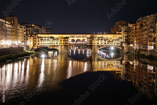 Ponte Vecchio over Arno River panorama in Florence Italy at night.