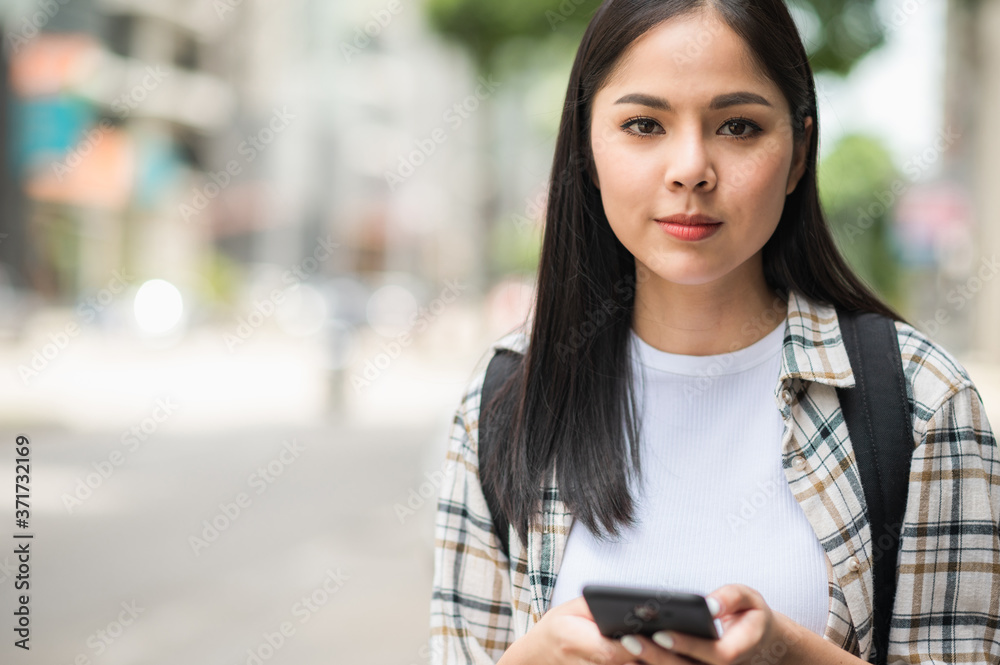 Young Asian beautiful woman travelers use her mobile phones to find travel locations and call for taxi transportation. Young Asian beautiful woman travelers use her mobile phones to find travel locations and call for taxi transportation.