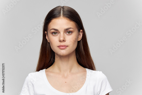 Portrait of a woman on a light background in a T-shirt and loose hair 