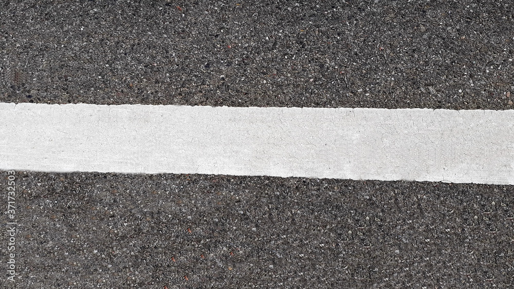 Fototapeta premium White paint line on asphalt road surface, with gray color guidelines on street, close up texture background concept, countryside Thailand.
