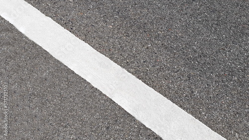 White paint line on asphalt road surface, with gray color guidelines on street, close up texture background concept, countryside Thailand.