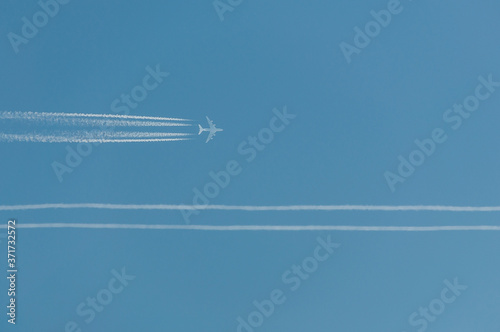 Błękitne niebo z samolotem pasażerskim i smugą kondensacyjną