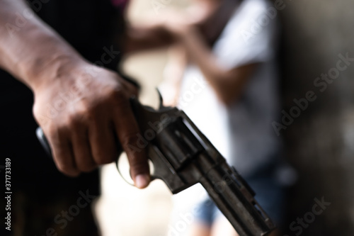 Crime concepts robbery aimed his gun at an asian girl © nonchanon