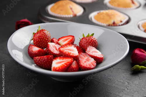 Plate with fresh ripe strawberries over dark grunge background
