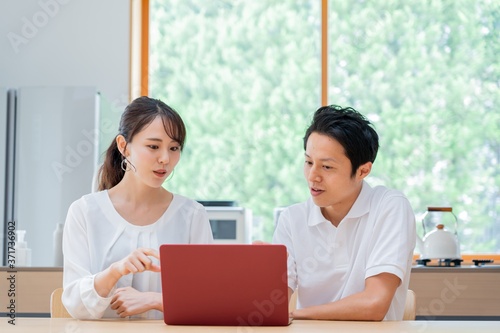 パソコンを見る 二人のアジア人 カップル 夫婦