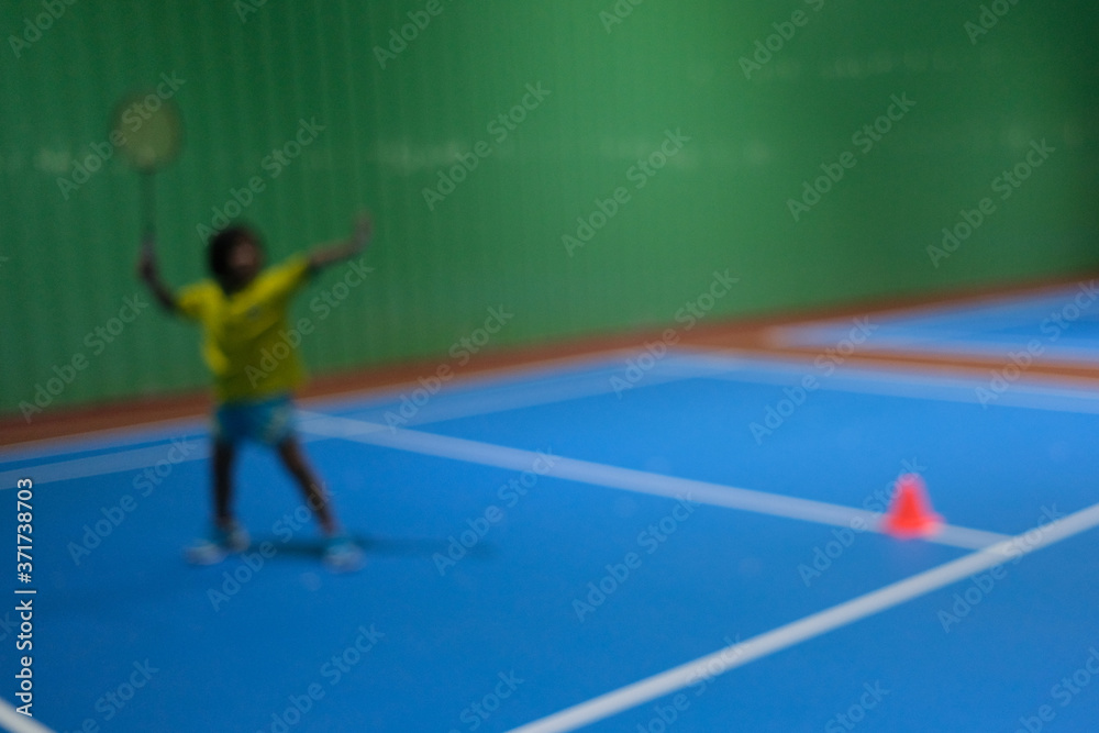 Blur background with little girl training class badminton at gym. Blur background with little girl training class badminton at gym.