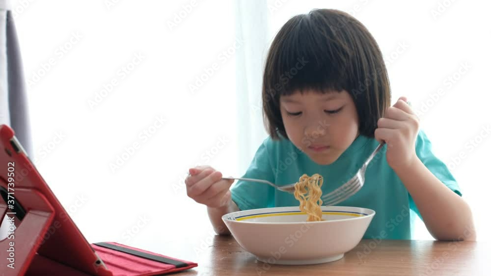 Asian kid eating noodles with blur background
Asian kid eating noodles with blur background