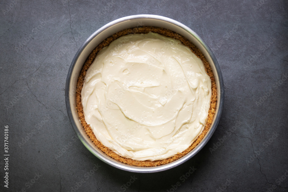 Plain cream cheese pie in a mold on black table background. Plain cream cheese pie in a mold on black table background.