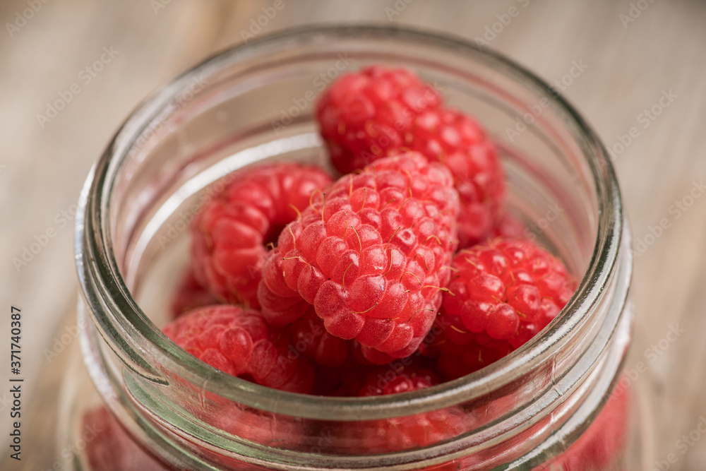 Ripe juicy raspberries in jar. Selective focus. Shallow depth of field. Ripe juicy raspberries in jar. Selective focus. Shallow depth of field.
