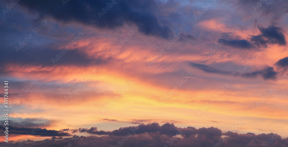 colorful sunset sky with dramatic clouds in pink, purple and yellow
