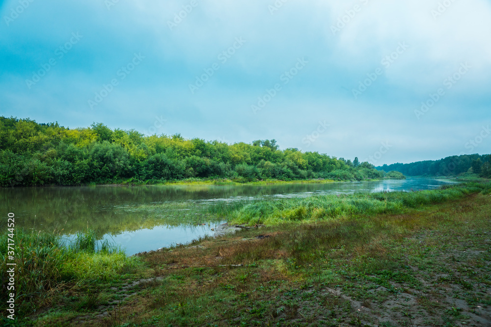 Calm river with forest on the other bank Calm river with forest on the other bank
