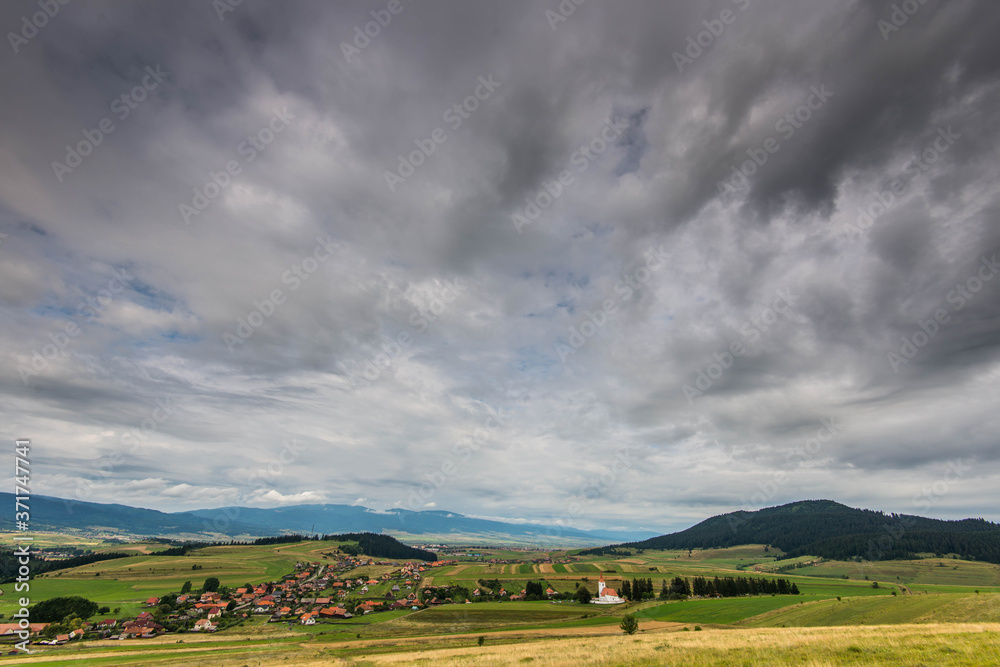 Wide angle view of a small hungarian village with catholic church in Transylvania, Romania.