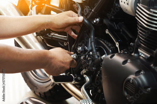 Obraz na płótnie mechanic hold Hex Key Wrench working on motorcycle at motorbike garage , concept of motorcycle maintenance and repair.selective focus w salonie