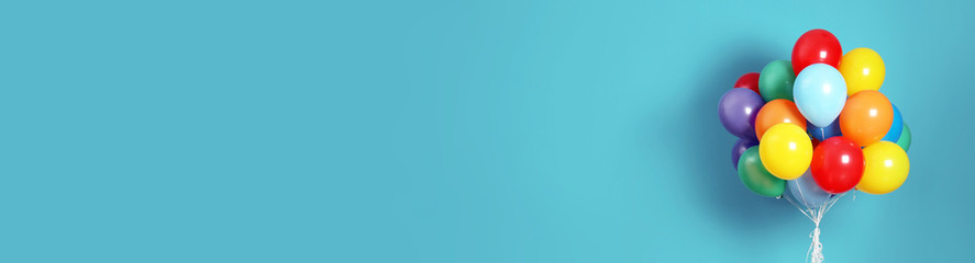 Bunch of bright balloons on light blue background, space for text. Banner design