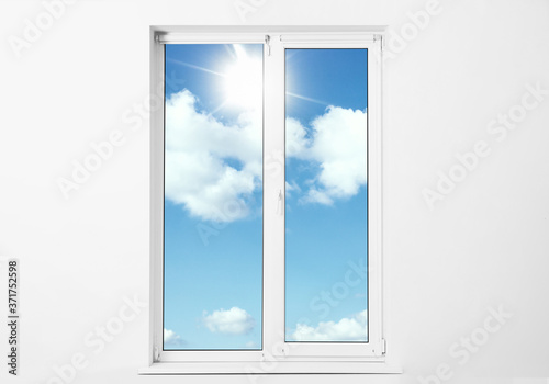 Beautiful view on blue sky with clouds through window