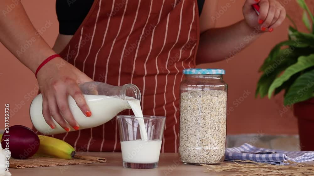 Mujer preparando el desayuno con leche y avena