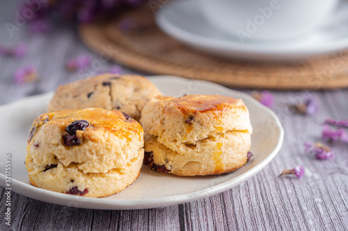 Side view of traditional British scones and cookie with a tea cup and blurred background
