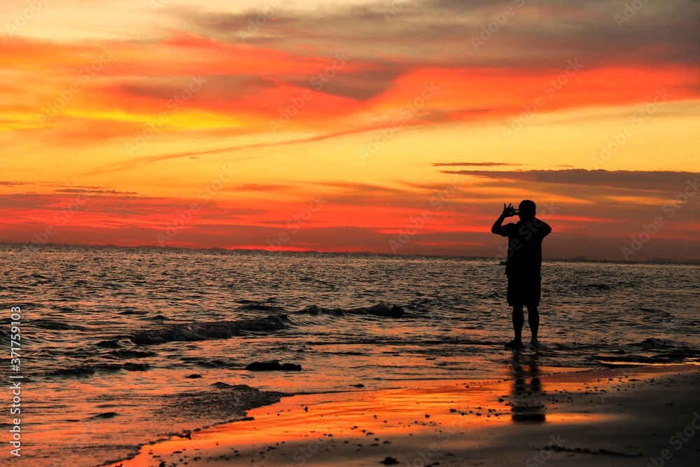 man photo shooting on the beach at sunset