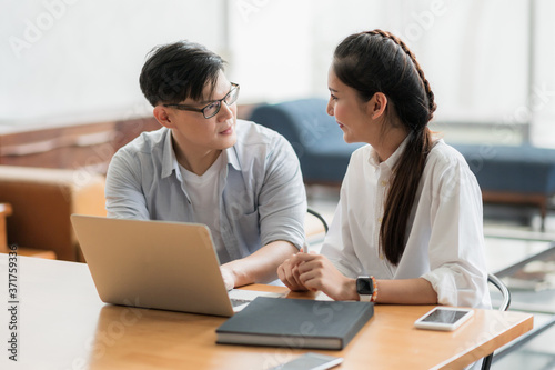 Asian business people man and woman conference talking and working with laptop together. Young couple work at home.