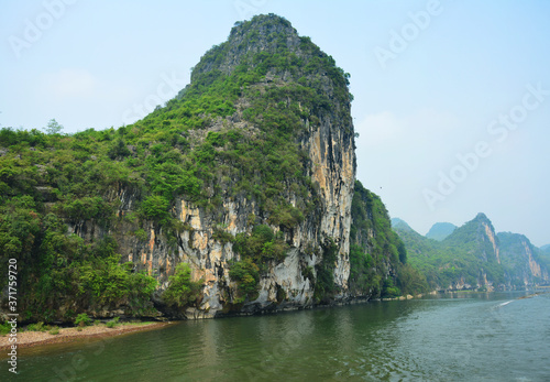 green mountain standing beside Li River in Guilin