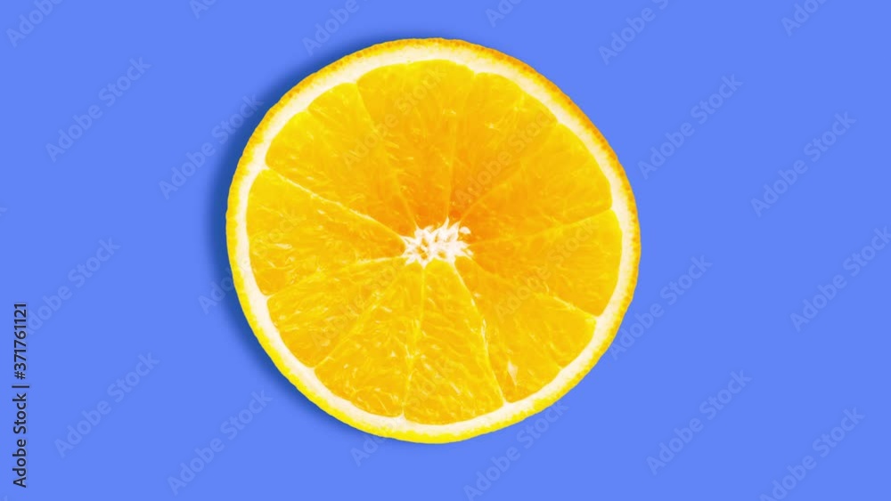 Rotating bright orange fruit slice cut animation. Blue background. Rotating bright orange fruit slice cut animation. Blue background.