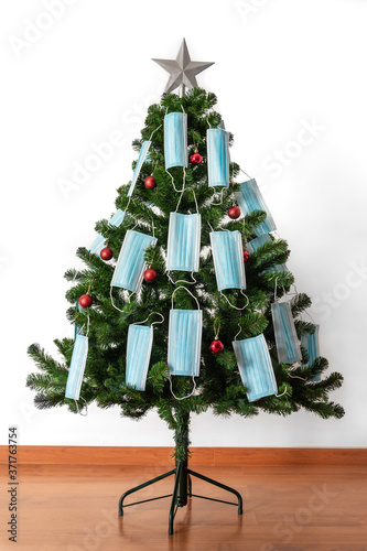 Christmas tree decorated with red balls, blue coronavirus masks and a big star.