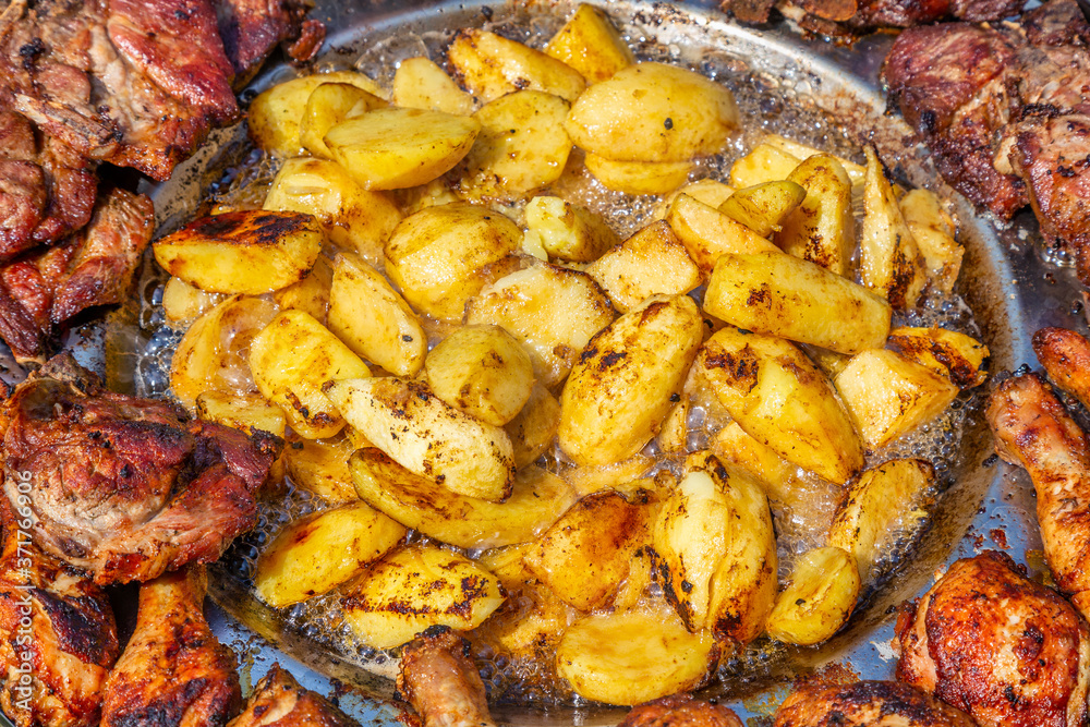 Potatoes frying in hot oil with pork and chicken Potatoes frying in hot oil with pork and chicken