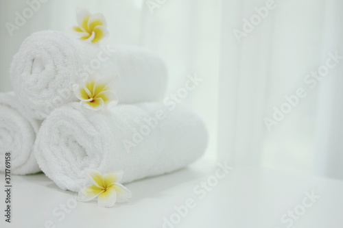 White towels rolled on a spa-themed table,Spa accessories,Beautiful composition of spa , spa relax concept, herbs for massage, beautiful spa set on wood table,For marketing products
