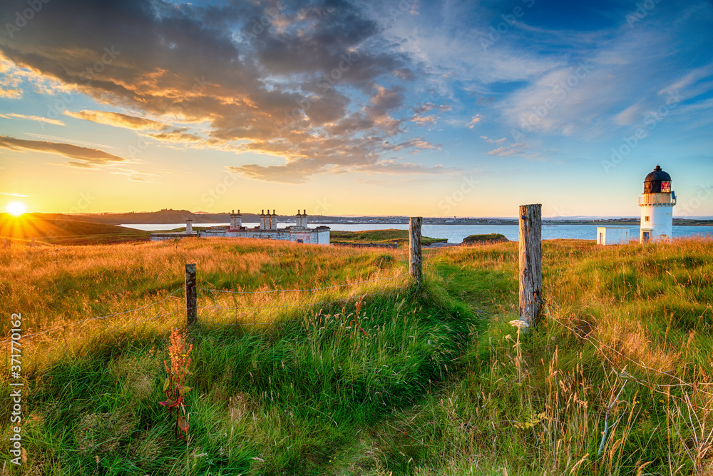 Beautiful sunset over the lighthouse and coastguard cottages at Arnish Point