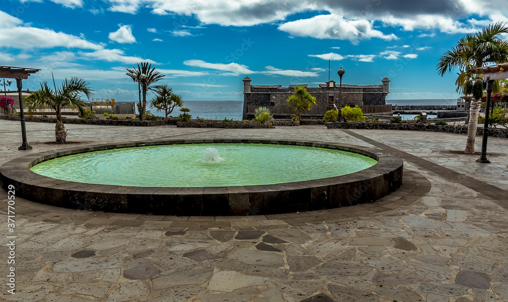 Fototapeta premium A view across an ornamental pond towards the Castle of Juan Bautista in Santa Cruz, Tenerife on a sunny day