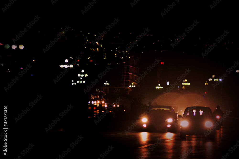 city of dead lights. dark world with little life. cars and people