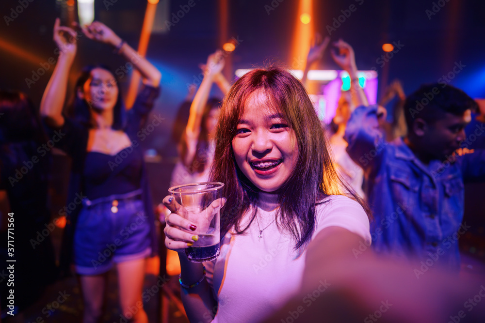young asian woman in nightclub with colorful light