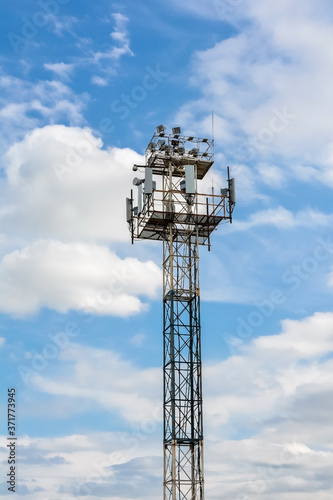 relay telephone and radio transmission tower against a blue sky with clouds