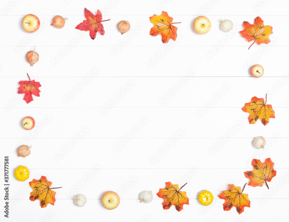 Fototapeta premium Autumn leaves and apples on a light wooden background
