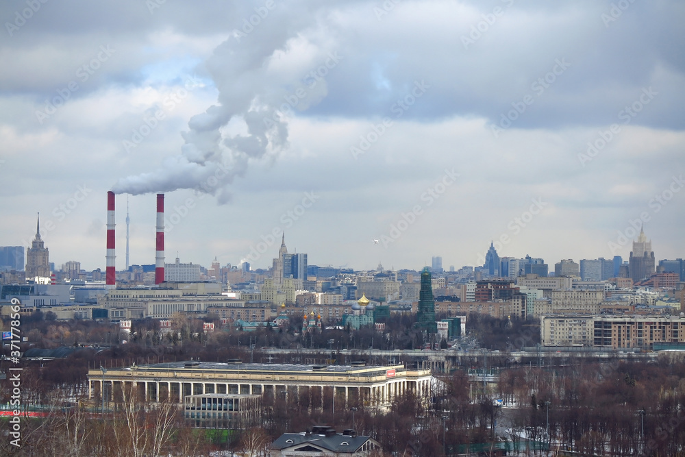 Smoke coming out of the chimneys of a thermal industrial station during winter in Moscow, Russia.