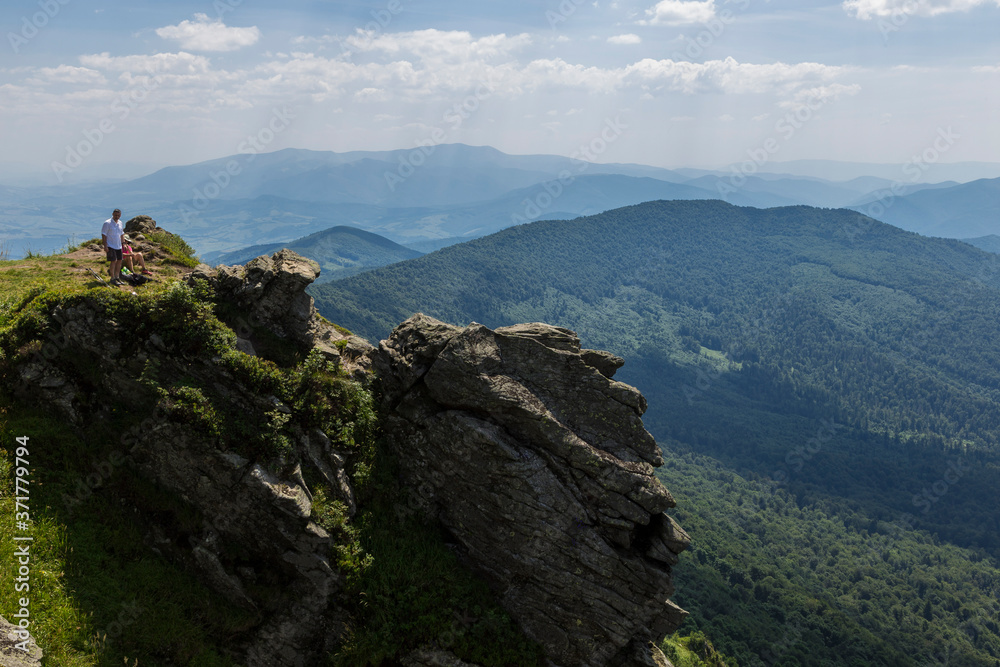 Summer landscape of the Carpathians on a sunny day. The main watershed. Mount Pikuy, Ukraine. Rock ledges on a background of mountains. Landscape with high mountains.