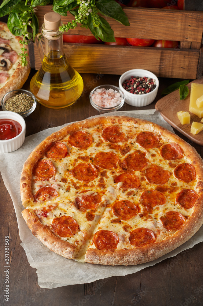 Hot cheese pizza with chorizo on rustic wooden table with ingredients