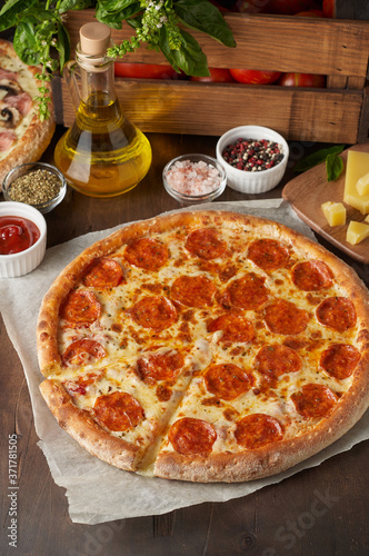 Obraz na płótnie Hot cheese pizza with chorizo on rustic wooden table with ingredients w salonie