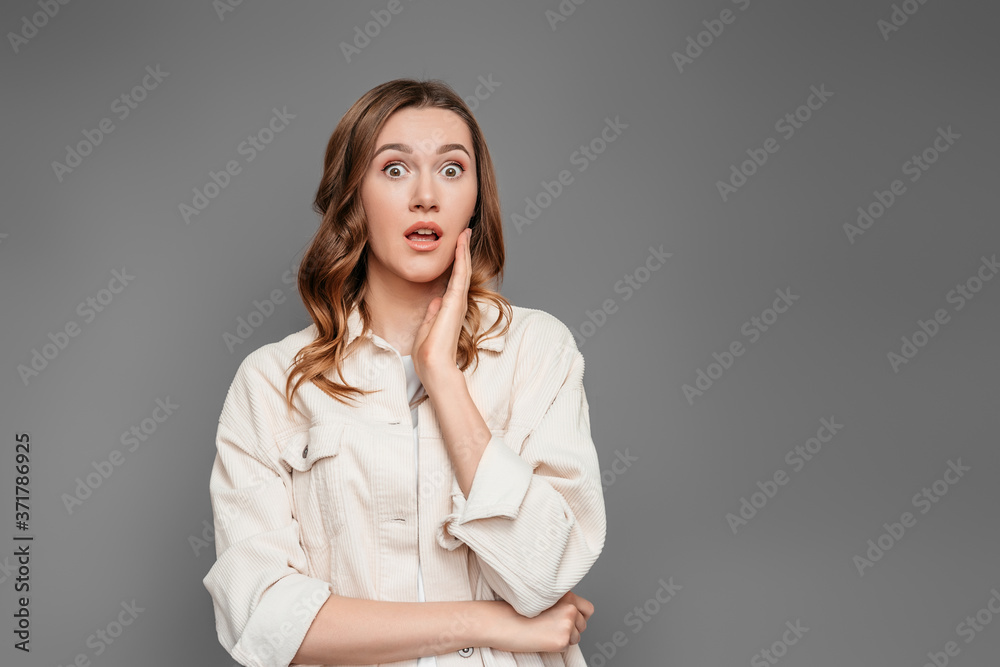 Portrait of scared shocked caucasian young female student isolated on dark grey background in studio Portrait of scared shocked caucasian young female student isolated on dark grey background in studio