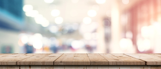 Abstract blurred image of department store with wooden table counter background for show , promote ,design on display concept