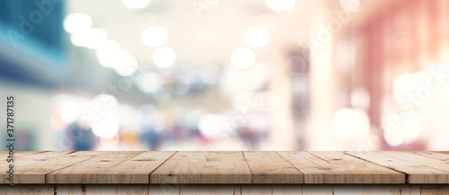 Abstract blurred image of department store with wooden table counter background for show , promote ,design on display concept