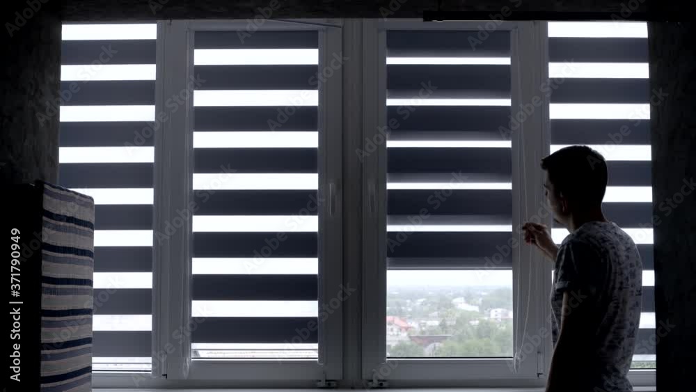 Man installing cassette roller blinds on windows Man installing cassette roller blinds on windows