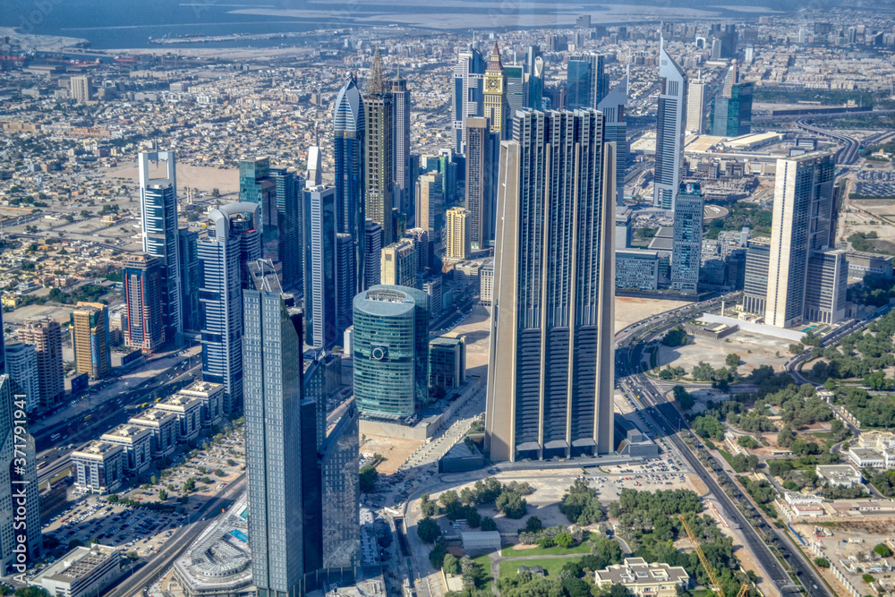 Fototapeta premium Dubai, United Arab Emirates - September 2, 2016. Urbanistic view of Dubai territories from the top of Burj Khalifa skyscraper, tall buildings on the sunny autumn day