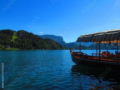A boat floating on a calm blue lake.